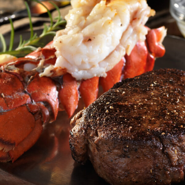 Dinner plate with beef medallion, lobster tail and mash potatoes.