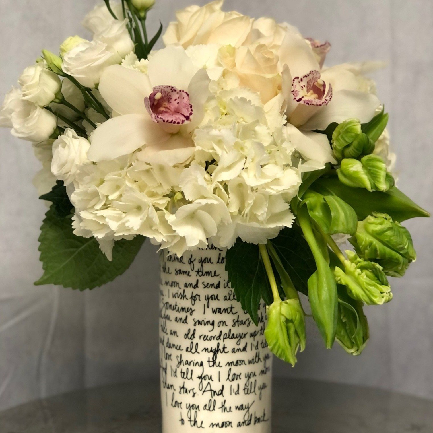 Love Story Photo of parrot tulips, white cymbidium orchids, white hydrangeas, roses and lisianthus in a vase with writing