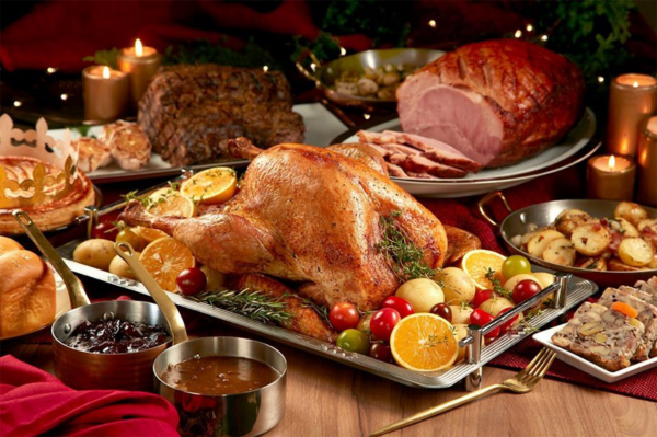 Photo of turkey and hams served with side dishes and sauce.